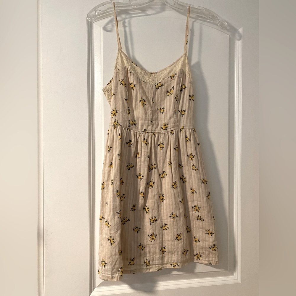Cream spaghetti strap dress with small yellow floral print and lace trim